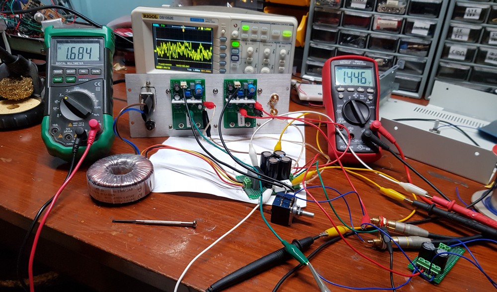 Testing the amplifier modules. The multi-meters are reading the voltage across a pair of 10R resistors that feed the power rails to the amps. The goal was to set the bias current to ~200mA at idle with the heatsink warmed up. Thus I was looking for them to stabilise at ~2V
