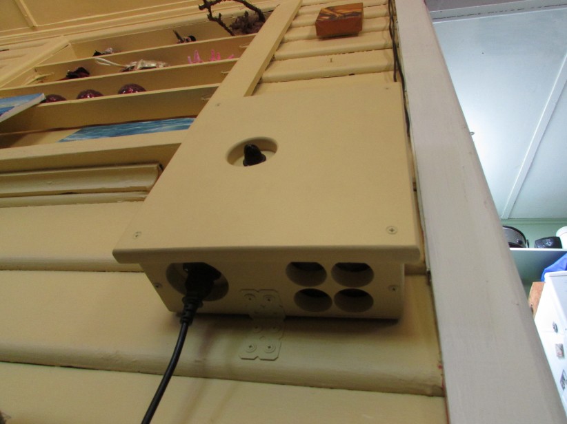 Underside of the completed light controller, showing the power cord socket and lower ventillation holes produced using a hole saw.