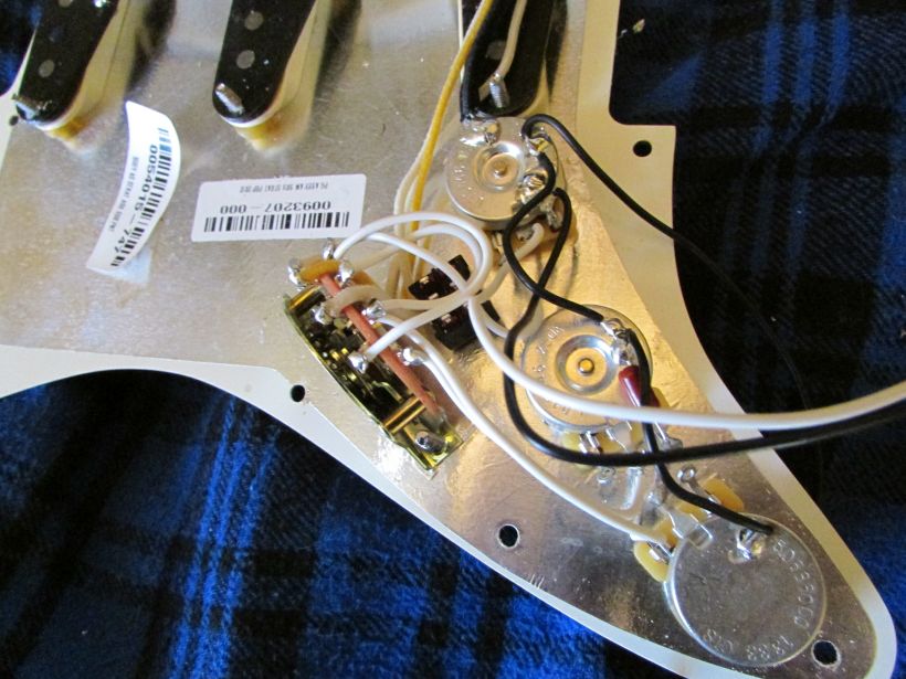 The default Stratocaster wiring scheme with the new switch mounted and ready to be wired in. Note all the black ground leads going to the rear of the volume pot.